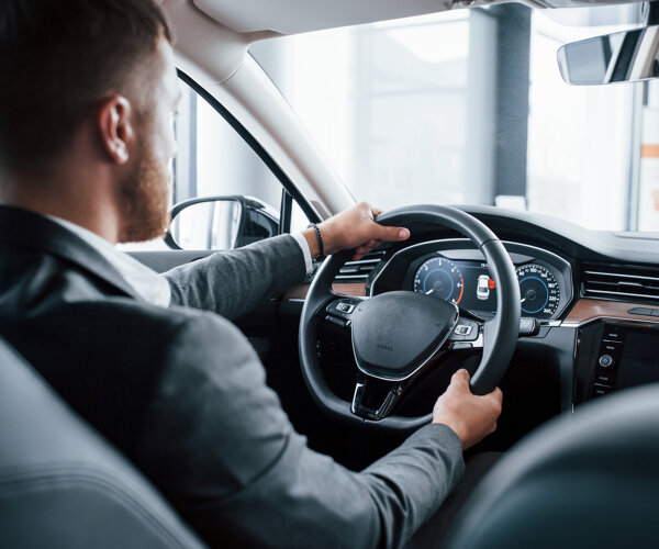 modern-businessman-trying-his-new-car-automobile-salon