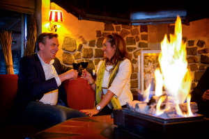 Man_en_vrouw_bij_haardvuur_Preston_Palace_toasten_rodewijn
